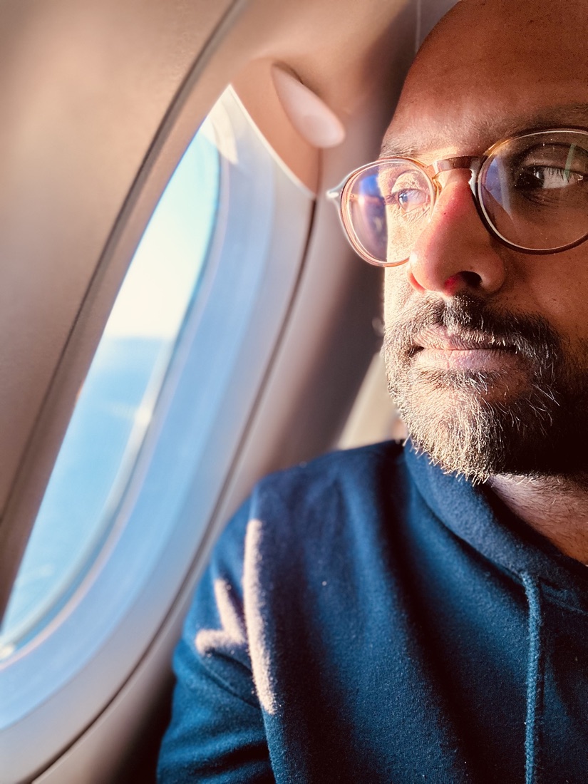 Kris looking out an aircraft window at golden hour